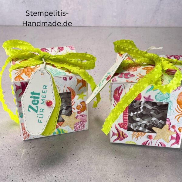 Handdekorierte Fensterschachtel 7 cm mit maritimen Motiven, Geschenkbox mit Fenster und Schleife in Grün, Detailansicht Geschenkschachtel Etikett „Zeit für Meer“, Offene Sichtfensterbox von oben, Fensterschachtel mit bunter Meeresdekoration, Geschenkverpackung mit transparentem Fenster, Handgemachte maritime Fensterschachtel mit Schleife